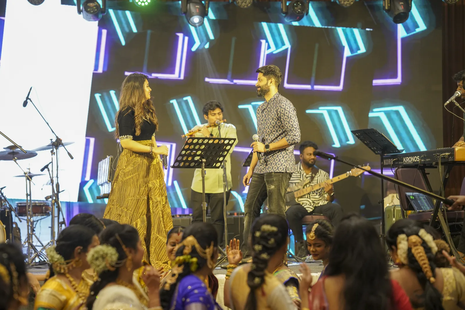 A live band on a neon lit concert stage run by Nigal Events